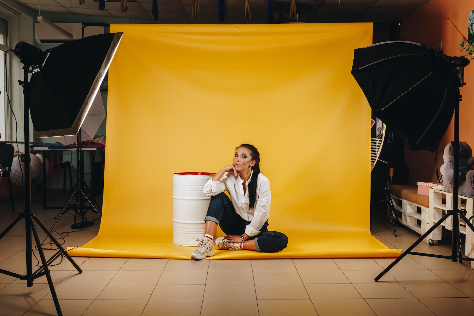 woman in white long sleeve shirt sitting on yellow floor tiles